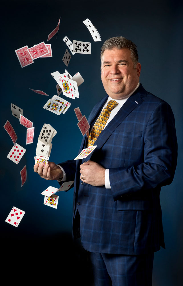 Scott the Magician with a tornado of cards shooting out of his hand.
