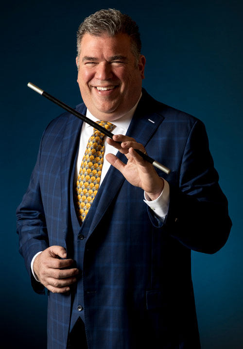 Scott the Magician with a Magic Wand on a dark blue background.
