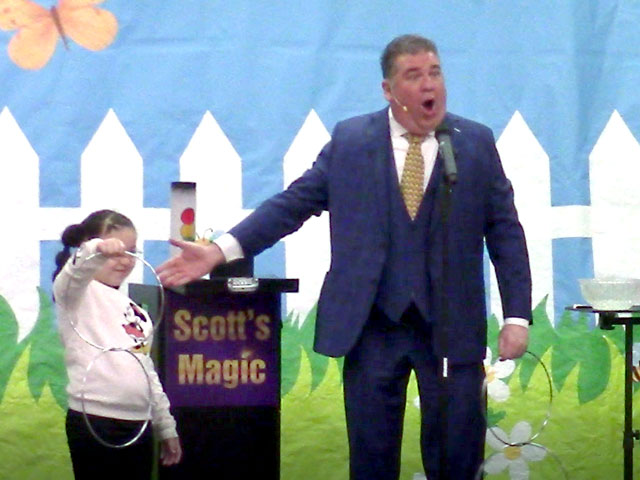 Scott the Magician at a school with a audience volunteer.